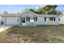 Ranch-style house with gray exterior, landscaping, and a single-car garage at 10841 Gawain Rd, Port Richey, FL 34668