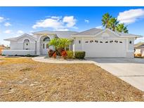 White one-story house with a two-car garage and landscaped yard at 13124 Lawrence St, Spring Hill, FL 34609