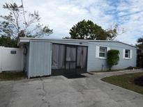Light blue house with a screened porch and small yard at 4011 W Mango Ave, Tampa, FL 33616