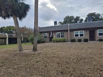 Exterior view of a condo building with landscaping and palm trees at 11203 Pembridge Ct # 1, Port Richey, FL 34668
