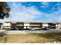 Two-story condo building with covered parking and lush landscaping at 4515 Marine Pkwy # 102, New Port Richey, FL 34652