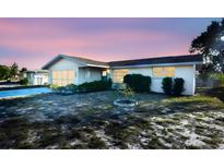 Ranch-style house with a flat roof, light-colored exterior, and a small front yard at 7714 Jasmine Blvd, Port Richey, FL 34668