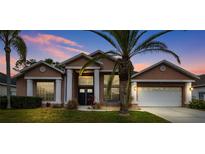 Two-story house with a double door entry and a three-car garage at 9105 Flagstick Ln, Hudson, FL 34667