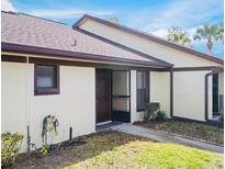 Exterior view of a condo with a brown door and light-colored walls at 1355 Powderpuff Dr # 908, Dunedin, FL 34698