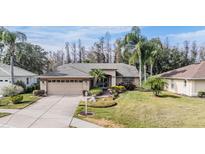 Single-story home with attached garage, landscaping, and driveway at 1413 Morning Rose Pl, Trinity, FL 34655