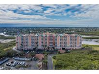 Aerial view of a waterfront condo building with parking and lush landscaping at 4516 Seagull Dr # 417, New Port Richey, FL 34652