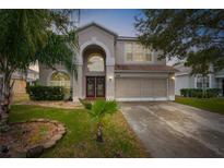 Two-story house with a large front yard, double doors, and attached garage at 13468 Haverhill Dr, Spring Hill, FL 34609