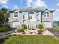 Two-story waterfront home with landscaped yard and attached two-car garage at 2013 Gulfview Dr, Holiday, FL 34691
