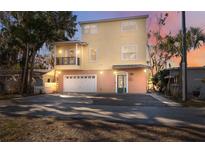 Two-story yellow house with balcony, garage, and landscaped yard at 5287 Tuna Ln, Weeki Wachee, FL 34607