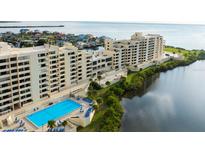 Aerial view showcasing condo building, pool, and waterfront location at 5915 Sea Ranch Dr # 501, Hudson, FL 34667