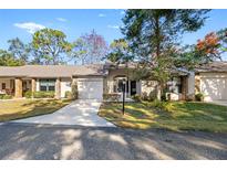 Front view of charming villa with driveway and landscaping at 6611 Sovereign Way, Spring Hill, FL 34606