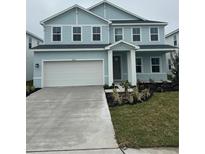 Two-story light blue house with white garage door and landscaping at 10122 Zennia Ln, Parrish, FL 34219