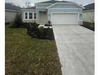 One-story home with light blue exterior, stone accents, and two-car garage at 10127 Zennia Ln, Parrish, FL 34219