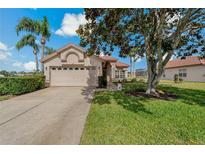 Charming single-story home featuring a red tile roof, manicured lawn, and mature landscaping at 1082 Dartford Dr, Tarpon Springs, FL 34688