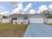 Charming single-story home with a white picket fence, blue siding, and a well-maintained front yard at 11731 Linden Dr, Spring Hill, FL 34608