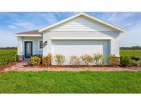 One-story home with light blue exterior, brick walkway, and a two-car garage at 2467 White Ladyfish Rd, Wimauma, FL 33598