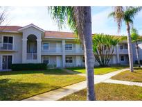 Exterior view of a two-story building with balconies and lush landscaping at 6801 Dali Ave # G104, Land O Lakes, FL 34637