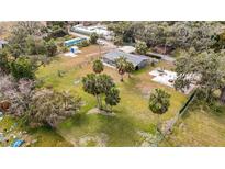 Expansive property featuring a single-Gathering home, lush greenery, and mature palm trees at 14034 Water Tower Dr, Hudson, FL 34667