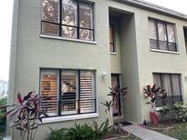 Light green two-story building with white shutters and landscaping at 1761 Cupecoy Cir # N-1, Lutz, FL 33558
