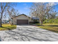 House exterior showcasing a two-car garage and a spacious driveway at 18104 Spencer Rd, Odessa, FL 33556