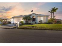 Single-story home with a two-car garage and landscaped lawn at 3912 Rudder Way, New Port Richey, FL 34652