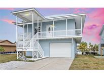 Inviting two-story coastal home featuring a spacious covered porch and convenient garage access at 4045 Centavo Ct, Hernando Beach, FL 34607
