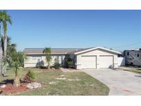 Single-story home with attached two-car garage and landscaped yard at 4949 Waterside Dr, Port Richey, FL 34668