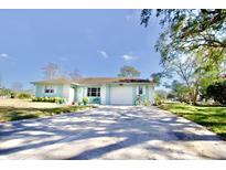Cute light blue house with a white garage door and a yellow bicycle parked in the driveway at 9240 Tiara Ct, New Port Richey, FL 34655