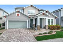 Charming two-story home featuring a manicured front yard, brick driveway and a neutral color scheme at 14855 Renaissance Ave, Odessa, FL 33556