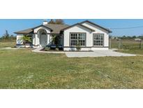 Charming single-story home featuring a well-manicured lawn, tasteful landscaping, and covered front porch at 15111 Peach Bloom Rd, Brooksville, FL 34614