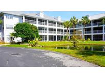 White two-story condo building with pond and landscaping at 2164 Vista Del Sol Cir # 505, Lutz, FL 33558