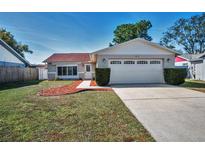 Charming single-story home featuring a two-car garage, well-maintained lawn, and attractive landscaping at 3713 Modesto St, New Port Richey, FL 34655