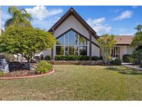 Beautiful two-story home featuring a large triangle window and meticulously maintained landscaping at 5410 Westshore Dr, New Port Richey, FL 34652