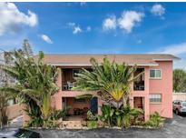 Two-story building featuring tropical landscaping, exterior balconies, and a charming, colorful facade at 7710 Bayshore Dr # 4, Treasure Island, FL 33706