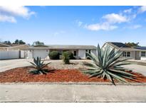 Charming single story home with well-maintained front yard landscaping and a two car garage at 10841 Piccadilly Rd, Port Richey, FL 34668