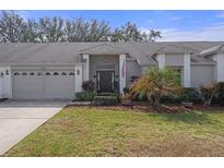 Charming single-story home boasts a well-manicured lawn, attached two-car garage, and inviting front entrance at 11008 Torrey Pines Ct, Hudson, FL 34667