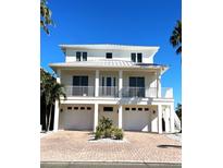 Two-story home featuring dual garage doors, white trim, and a balcony overlooking the front of the property at 1421 Apollo Beach Blvd, Apollo Beach, FL 33572