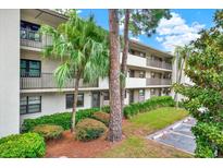 Condominium exterior with well-maintained landscaping and multiple stories of residences, and covered parking at 3038 Eastland Blvd # F103, Clearwater, FL 33761