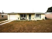 Charming single-story home with a covered porch, well-lit windows, and a comfortable bench at 3523 Cambridge St, New Port Richey, FL 34652