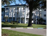 Three story white building with balconies, green grass and mature trees at 4801 Airport Rd # 208, Zephyrhills, FL 33542