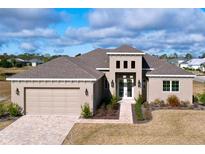 Beautiful single Gathering home featuring a three-car garage and well-manicured front lawn at 9065 Mississippi Run, Weeki Wachee, FL 34613