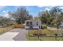 Charming home featuring a cozy front porch, a gravel driveway and a newly installed wooden fence at 9250 Peony St, New Port Richey, FL 34654