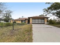 Inviting single-story home with a spacious driveway and an attached two-car garage at 1358 Newhope Rd, Spring Hill, FL 34606