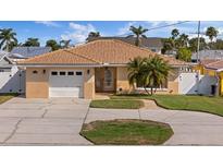 Charming home with a neutral color scheme, attached garage, and tropical landscaping at 4007 Floramar Ter, New Port Richey, FL 34652