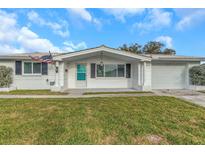 Charming single-story home with a well-manicured lawn and American flag at 5122 Bonito Dr, New Port Richey, FL 34652