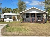 Charming one-story home featuring a cozy front porch and well-maintained lawn at 7017 Mccray Dr, Hudson, FL 34667