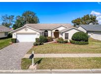 Charming single-story home features a manicured lawn, paved driveway, and attached two-car garage at 8447 Pavilion Dr, Hudson, FL 34667