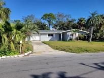 Charming single-story home with a well-manicured front lawn and mature landscaping in a desirable neighborhood at 103 Carlyle Dr, Palm Harbor, FL 34683