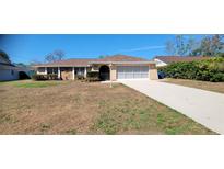 Charming single-story home featuring a well-maintained lawn and a two-car garage, perfect for suburban living at 2013 Meredith Dr, Spring Hill, FL 34608