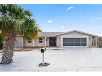 Charming single-story home with palm tree, gray accent, and a spacious driveway leading to a screened-in two-car garage at 3736 Sail Dr, New Port Richey, FL 34652